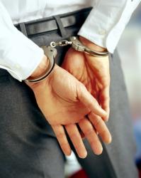 White Collar Professional in Handcuffs being treated like a criminal